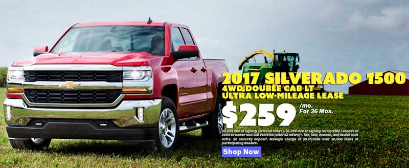 A red Chevy Silverado 1500 parked on a farm field