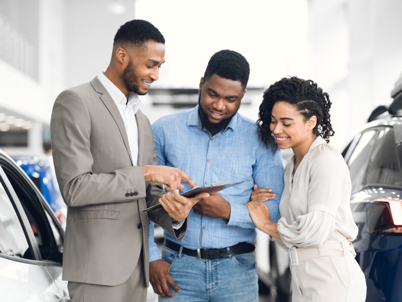 Couple looking through car options with sales representative - i.g. Burton Chevrolet of Milford in Milford DE